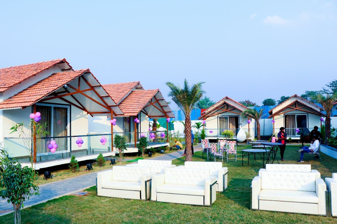 Row of garden cottages with tiled roofs and lawn seating