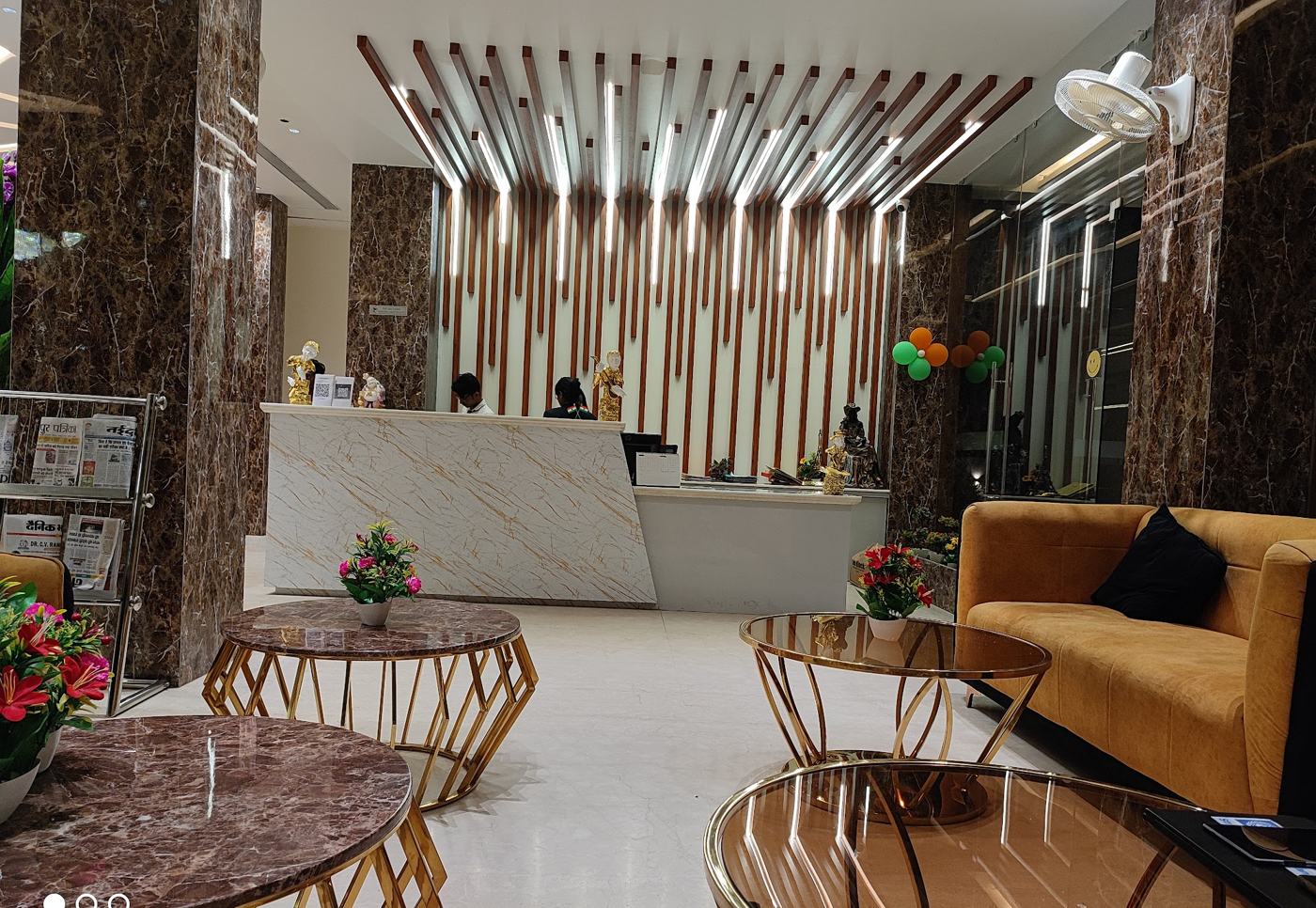 Lobby lounge with gold tables and timber slat ceiling