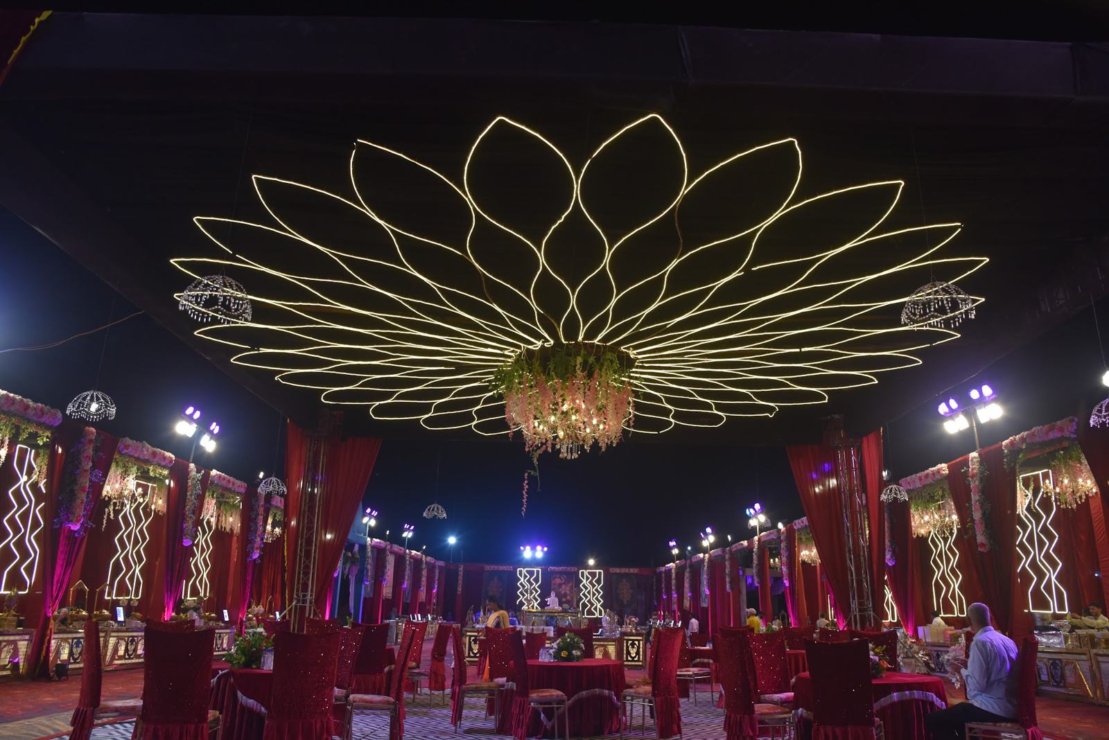 Lotus-shaped light canopy over a wedding reception at night