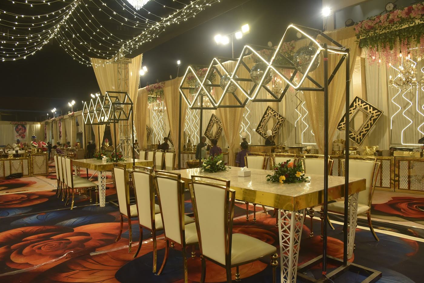 Gold wedding dining setup under geometric lights